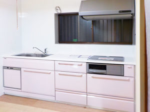 ピンクの扉材のシステムキッチン